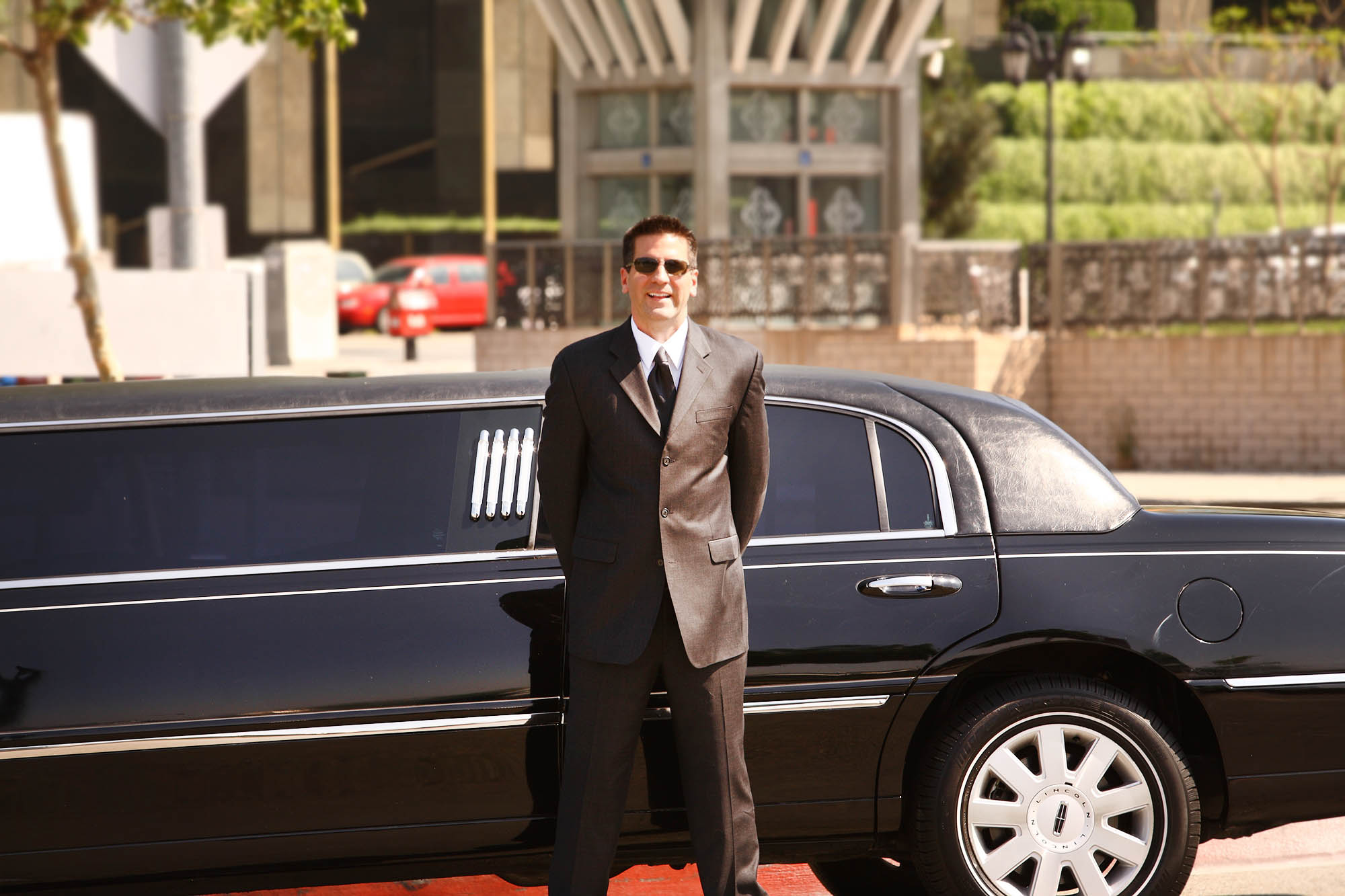 Chauffeur waiting outside stretch limo